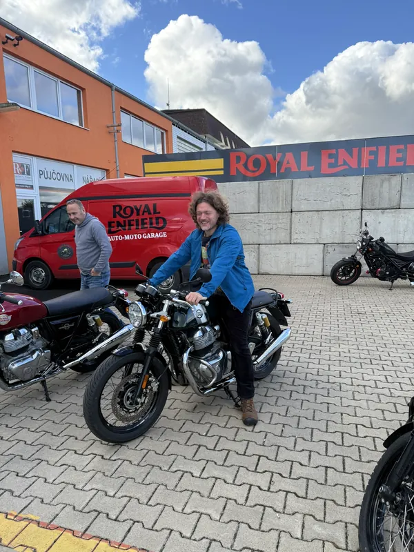 Lächelnde Fahrerin auf einem Royal-Enfield-Vorführmotorrad vor der GARAGE