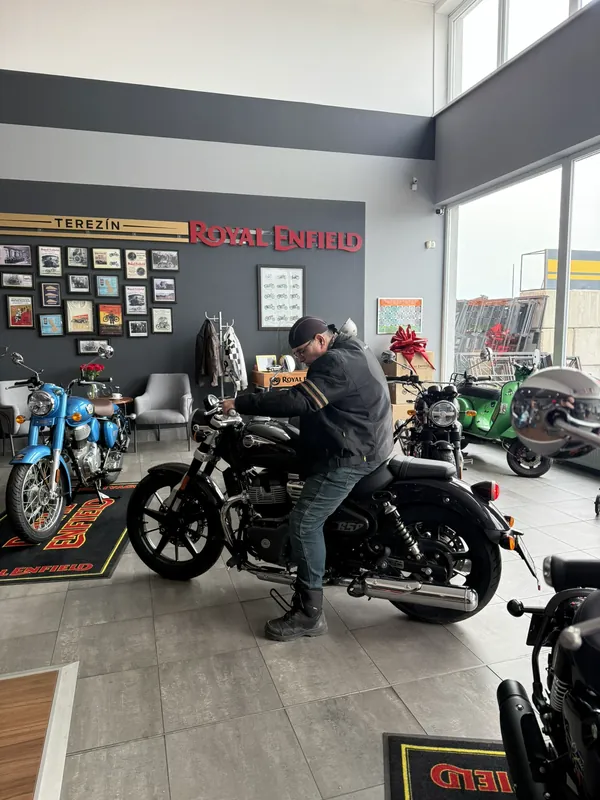 Kunde probiert die Sitzposition auf einer Royal Enfield im Showroom aus