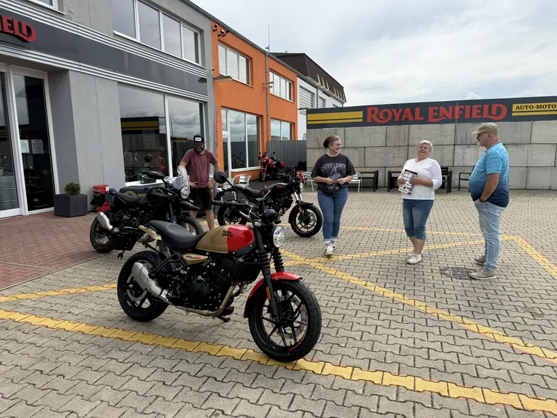 Royal-Enfield-Demomotorrad und Kunden im Hof der GARAGE in Bohušovice