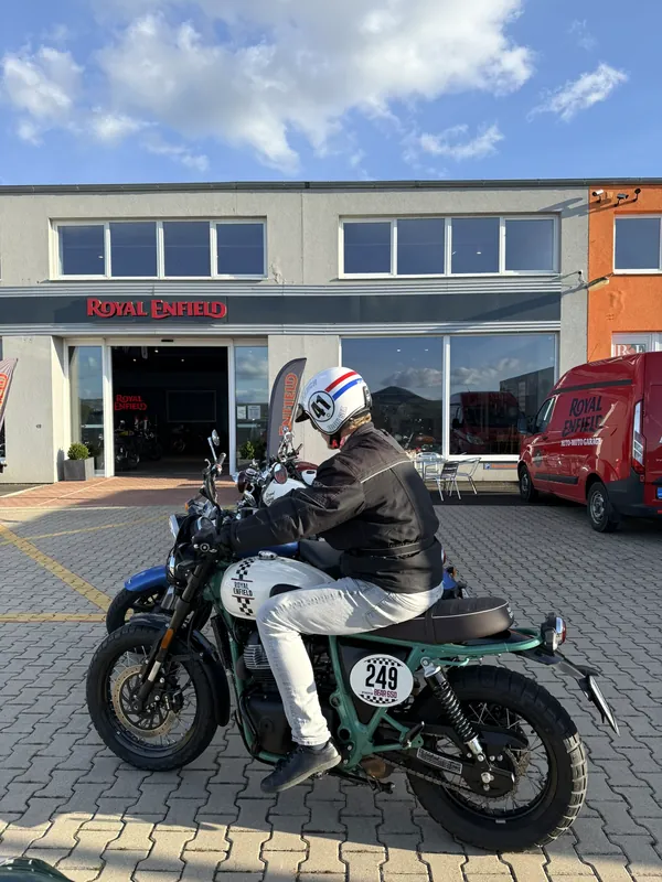 Ein Fahrer mit Helm startet eine Demofahrt vor der Royal Enfield GARAGE