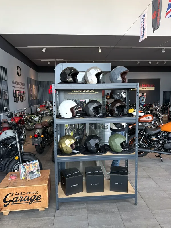 Regal mit Royal Enfield Helmen im Showroom der GARAGE