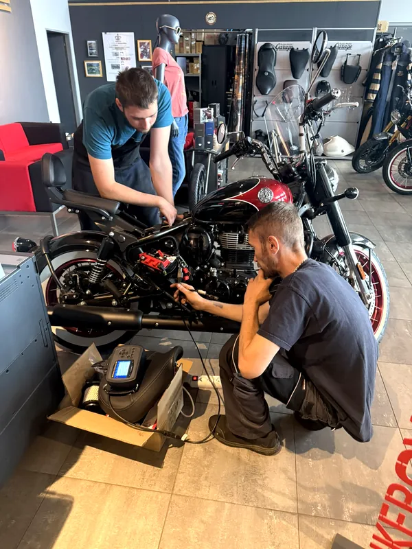 Zwei GARAGE-Mechaniker arbeiten an einem Royal Enfield Motorrad