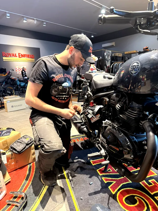 Ein Mechaniker bereitet ein Royal Enfield Motorrad zur Übergabe vor