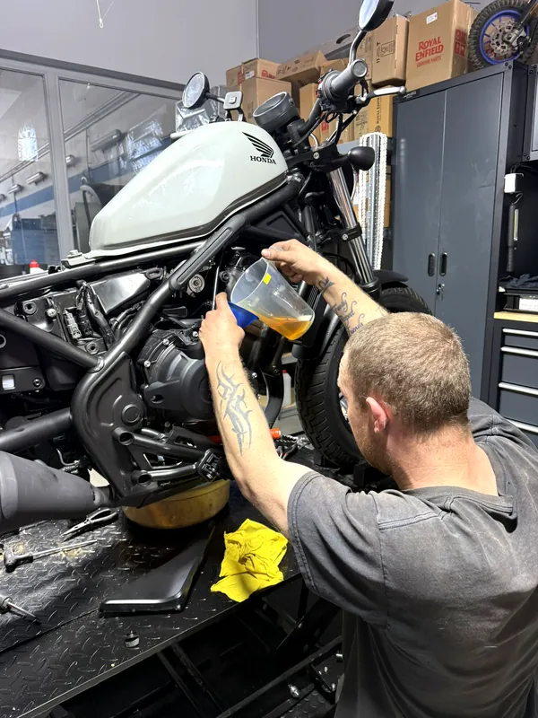 Ein Mechaniker füllt Öl in ein Royal Enfield Motorrad ein