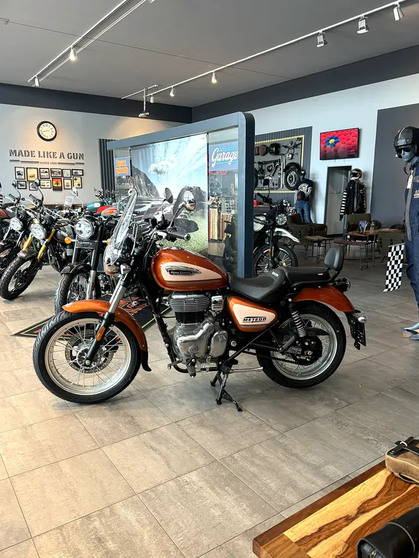 A motorcycle with an orange tank in the showroom