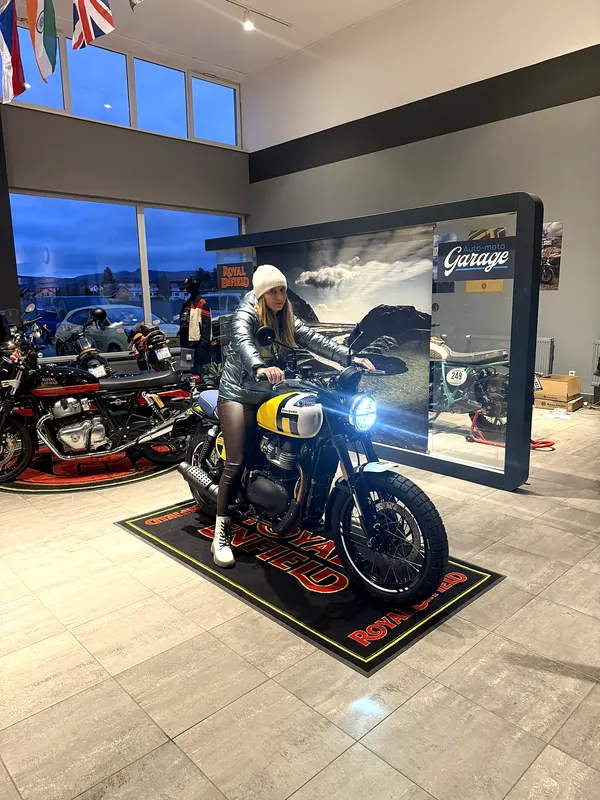 A female visitor tries out a motorcycle in the showroom
