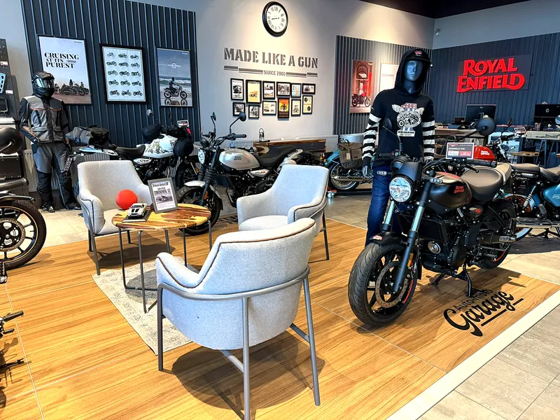 Armchairs and a small table among the motorcycles in the showroom