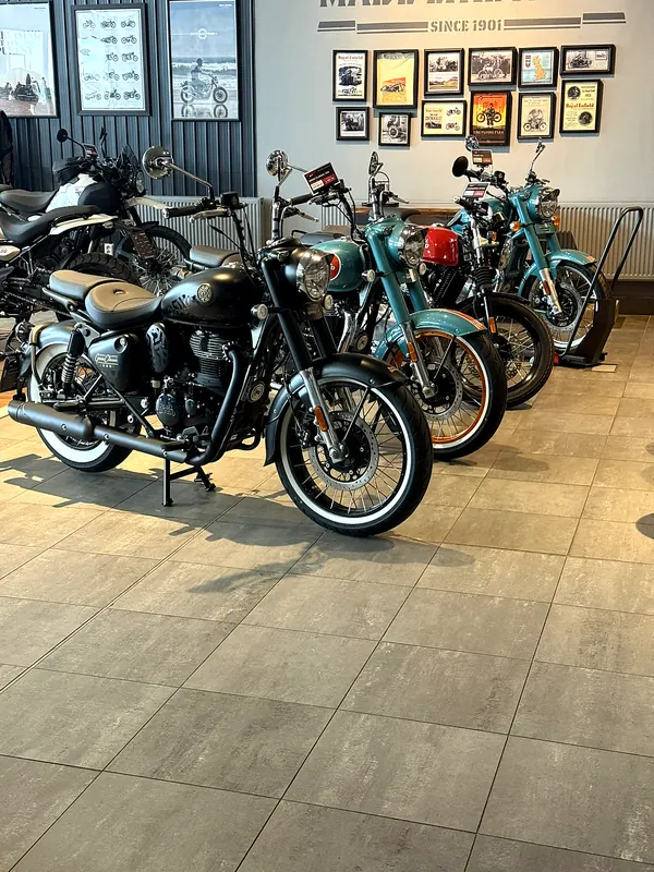 Motorcycles by the wall with paintings in the showroom