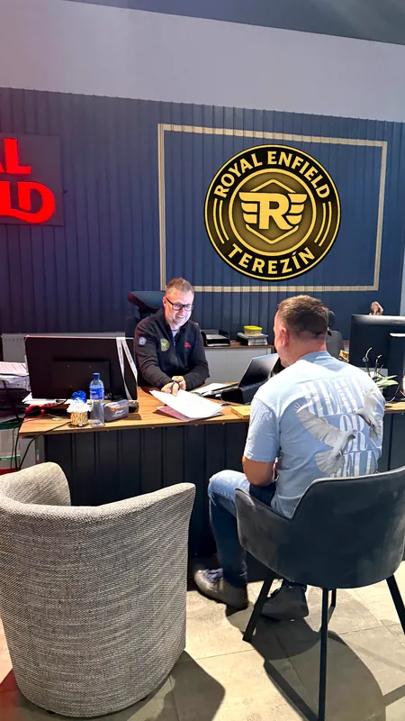 Ein Kunde mit einem Verkäufer am Tisch in der Royal Enfield GARAGE